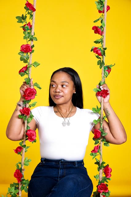 Studio portrait on a flower-wrapped swing.