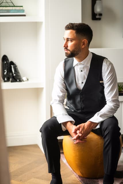 Groom getting ready, vest and bow tie, before the ceremony.