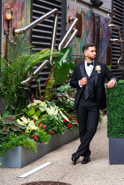 Groom portrait against a tropical, industrial-chic courtyard.