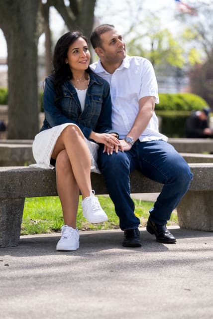 Engagement session, seated together on a park bench.