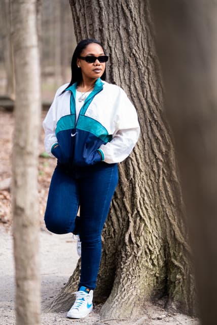 Personal brand session, vintage windbreaker, leaning on a tree.