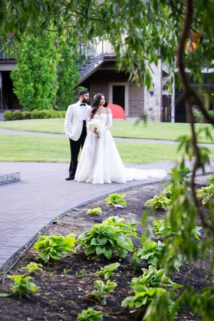 Bride and groom walking the venue grounds at golden hour.