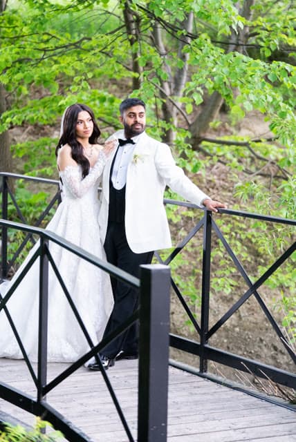 Bride and groom portrait on a garden footbridge.