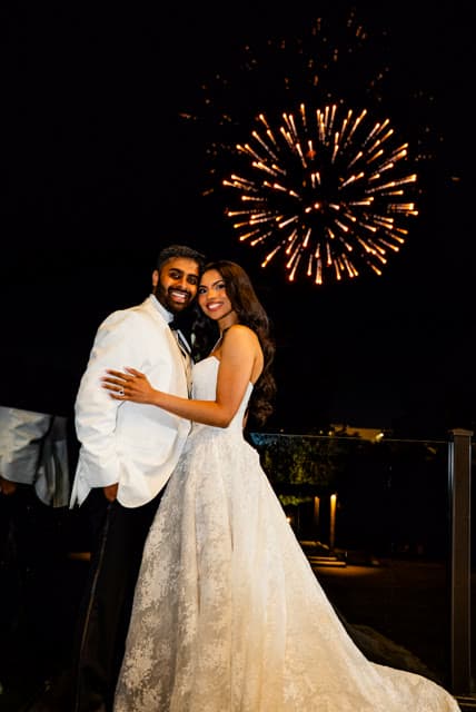 Bride and groom under fireworks at the reception.